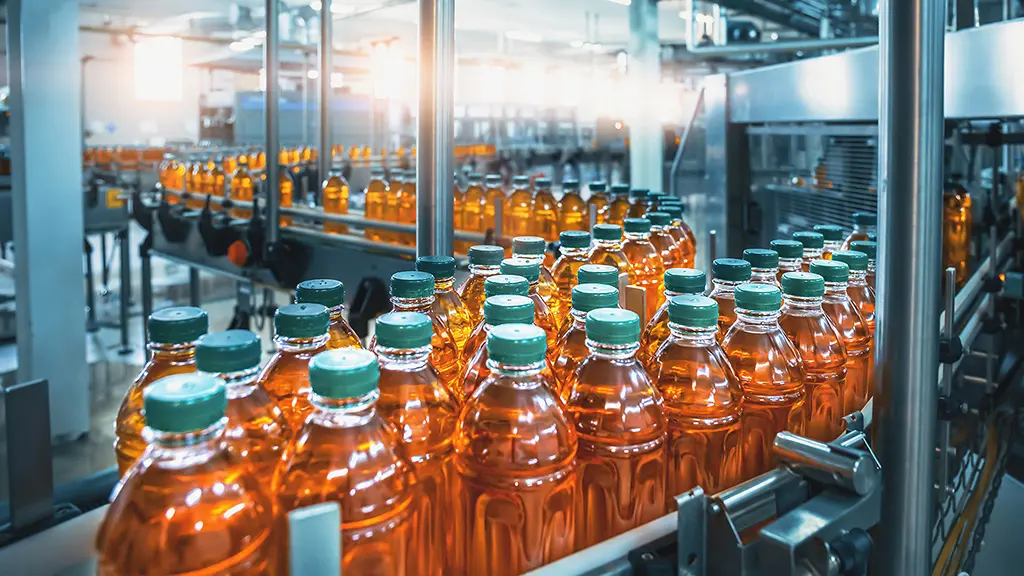 Automated High-Speed Bottling Line | Decimo Srl. Automated bottling line for fruit juice in a factory.
