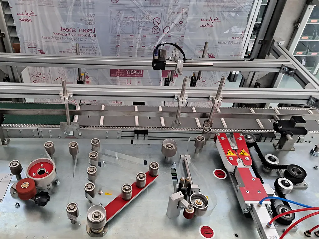 Testina del prototipo macchina Manigliatrice Elettronica per l'applicazione di maniglie adesive su scatole in cartone.