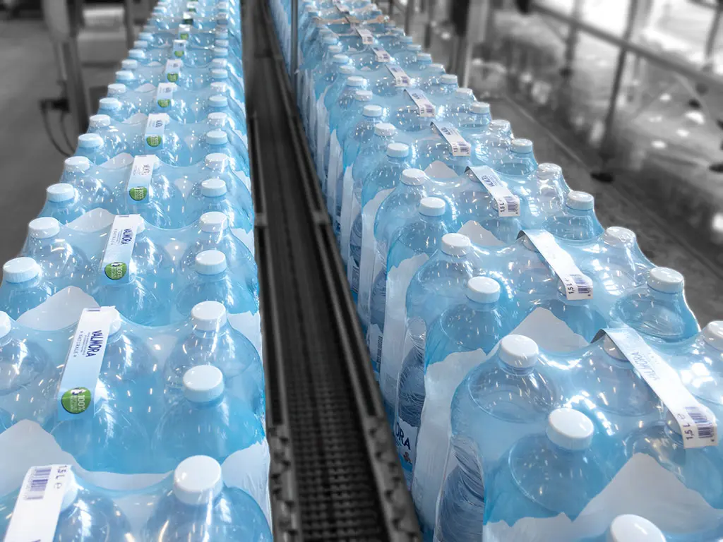 Packs of bottles with handle on conveyor Packs of bottles with handle on conveyor